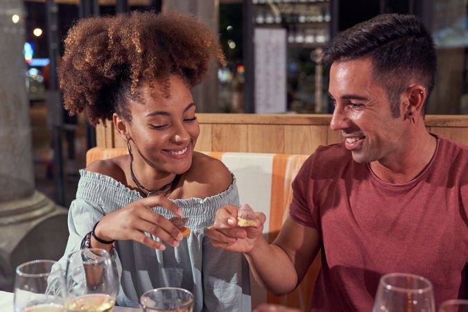 Content multiracial friends eating in restaurant