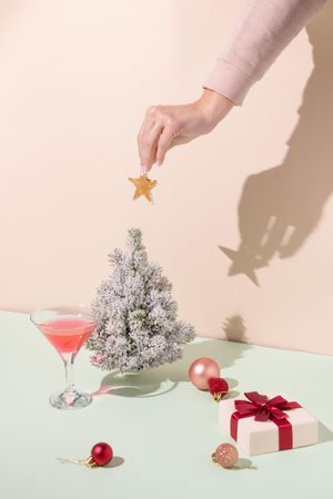 Woman’s hand placing Christmas tree decoration