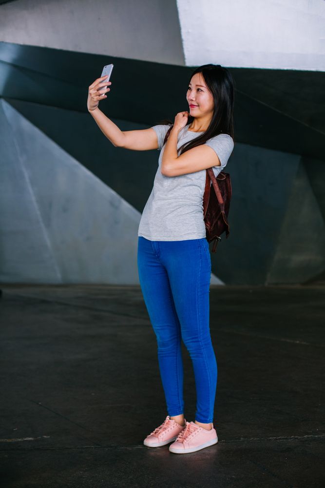 Asian female taking selfie in underground passage