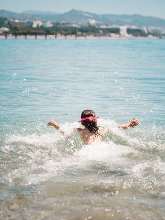 Cheerful girl having fun in warm sea