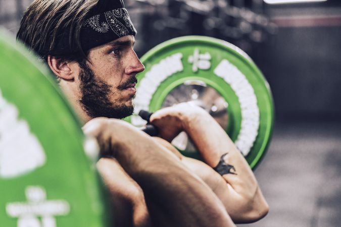 strong and athletic man doing barbell workout in modern gym