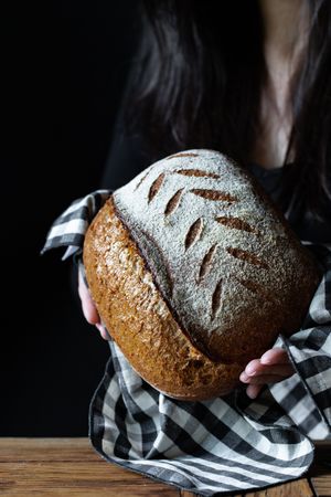 Crop person holding some bread