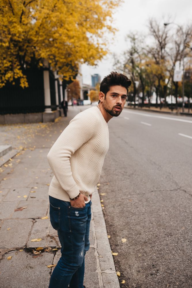 Young male looking for car on roadside