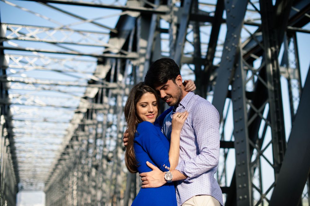 Amorous couple bonding on railway under bridge