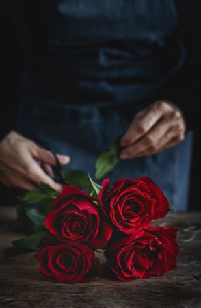 Unrecognizable woman making a bouquet of red roses
