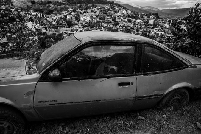 Old ruined car overlooking Mexican town