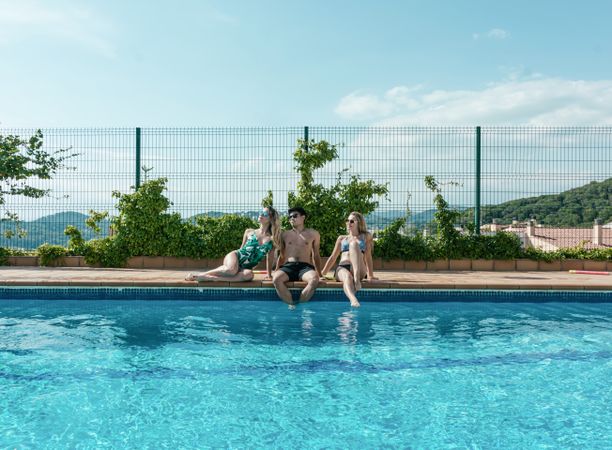Friends playing with water pistols in the pool