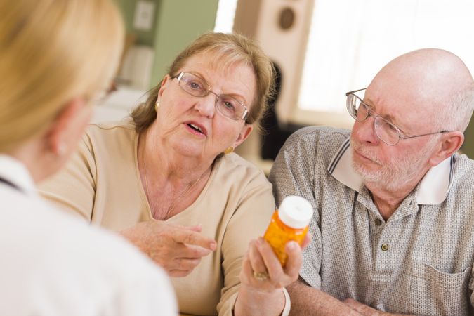 Doctor or Nurse Explaining Prescription Medicine to Older Couple