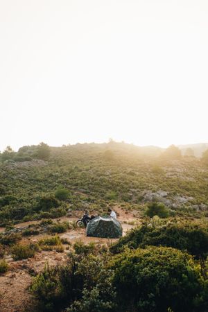 Motorcycle with tent in a field, vertical