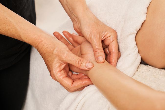 therapist massaging a woman's hands. Decontracting hand massage