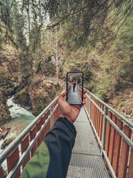 Tourist taking photo while walking on footpath