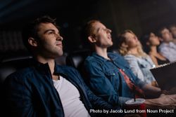 Young man with friends watching movie in cinema 5wqaLb