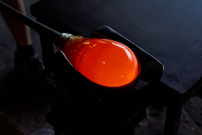 Liquid glass on blowpipe on marver