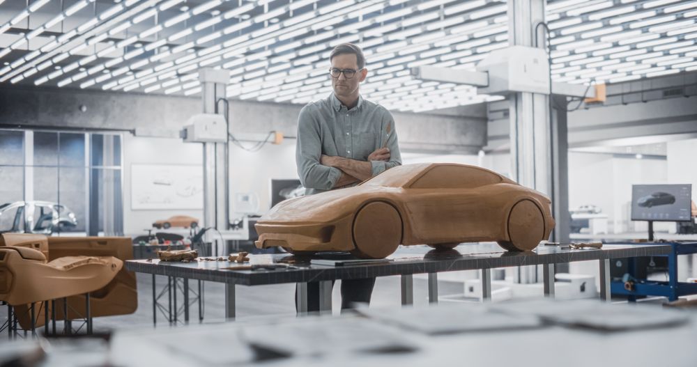 Automotive Designer Using a Spatula to Create a Prototype Car Out of Polymer Modeling Clay.