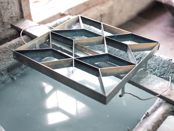 Metal mold above water in workshop