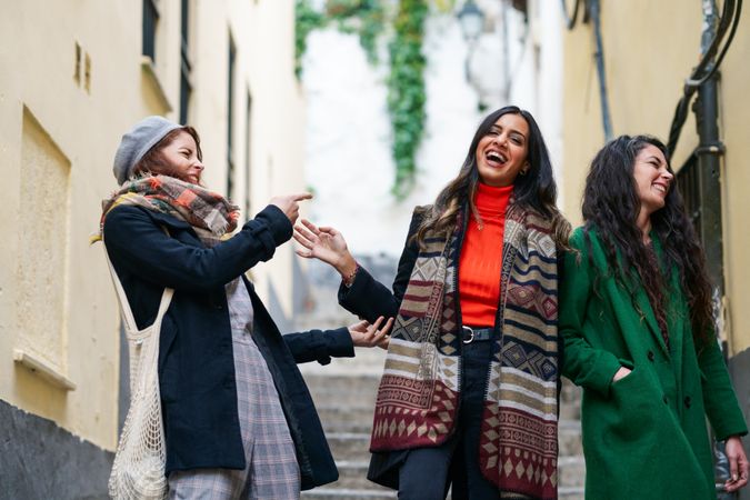 Three female friends dressed in autumn clothes together on a walk