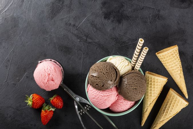 Bowl with Neapolitan ice cream on dark background.
