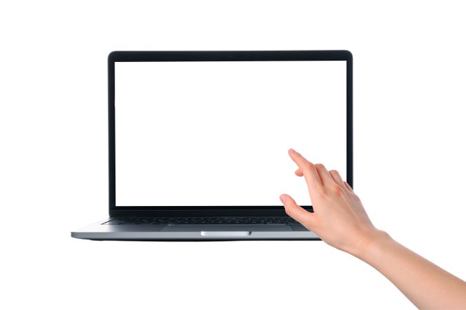 User's hand reaching out to touch the screen of a laptop device