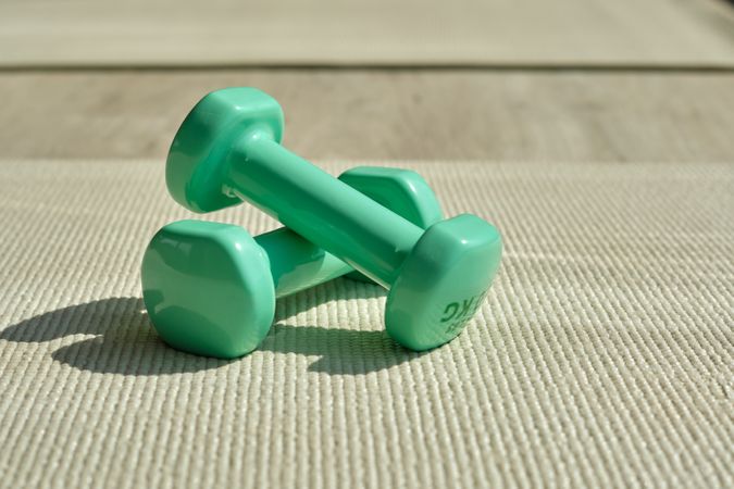 Dumbbells placed on mat in daytime