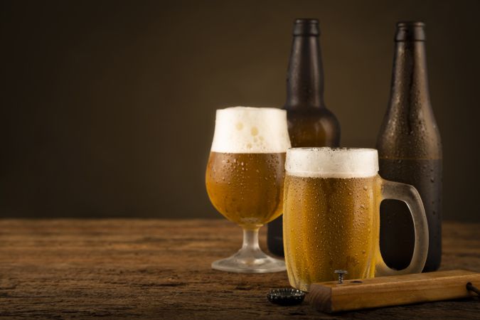 Glass full of cold beer on the wooden table