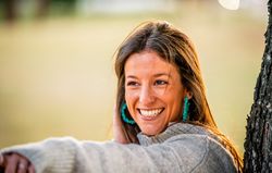 portrait of young woman sitting on grass in park