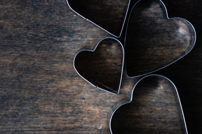 Heart shaped cookie cutters on wooden table with copy space