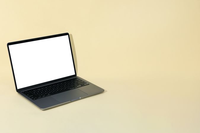 Laptop with mock up screen in cream room with copy space