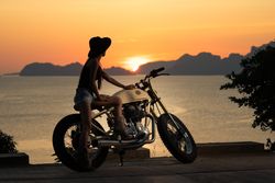 Woman with motorbike near sea