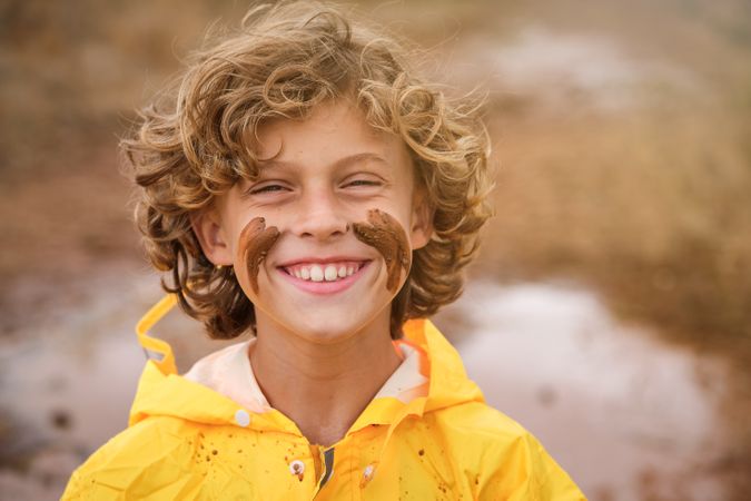 Positive child with mud on face