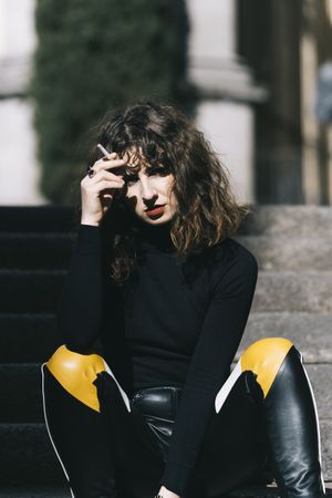 Young woman smoking cigarette in the street