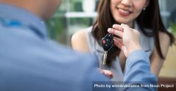 Female receiving car keys from male bE3wn5