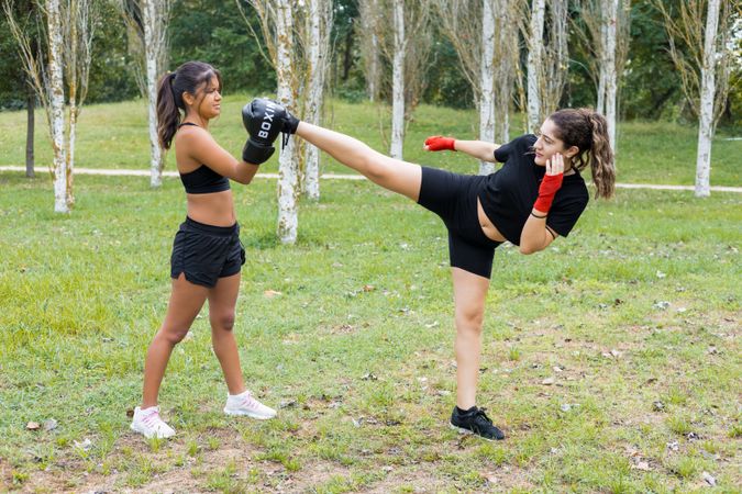 Female boxers training boxing sparring and kicking outdoors