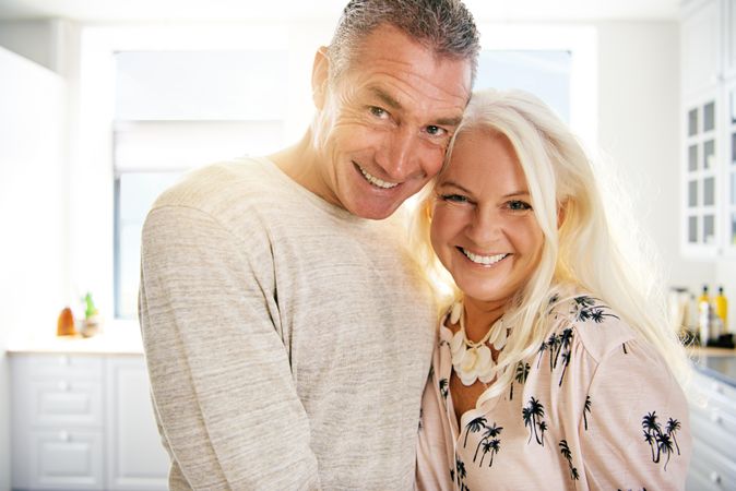 Portrait of older adults smiling in a bright kitchen