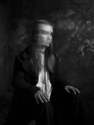 A young woman remains seated while turning her head, creating a blurred trail