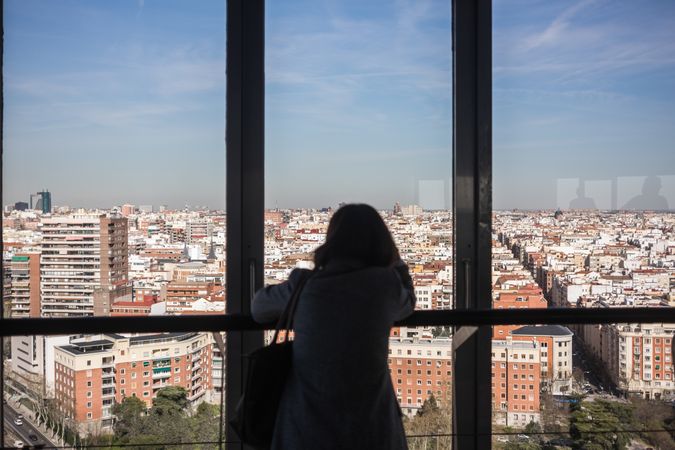 Anonymous woman looking out balcony window