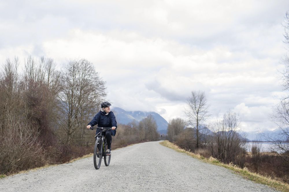 Woman riding a bicycle around a lake