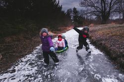 Children playing on frozen stream in the woods 47qer0