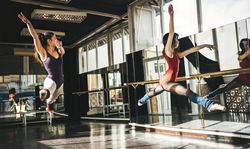 Ballerina jumping high above floor