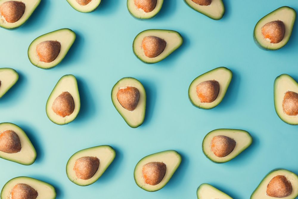 Avocado halves pattern on a pastel blue background