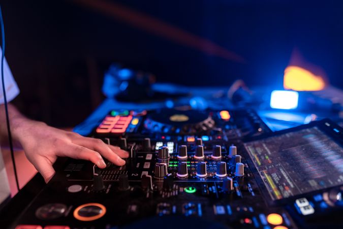 Hands of a young DJ on turntable in a disco