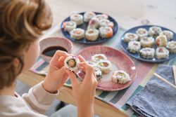 Little boy eating rolls in room