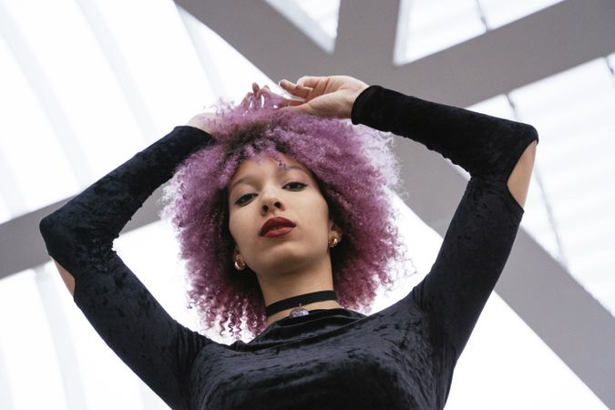 Stylish woman with pink hair looking at camera