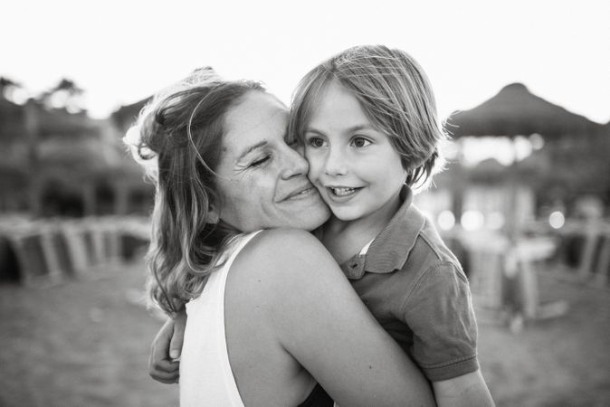 Mother kissing son on beach