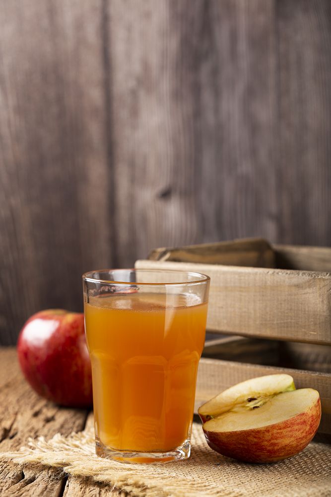 Apple juice and red apples on the table.