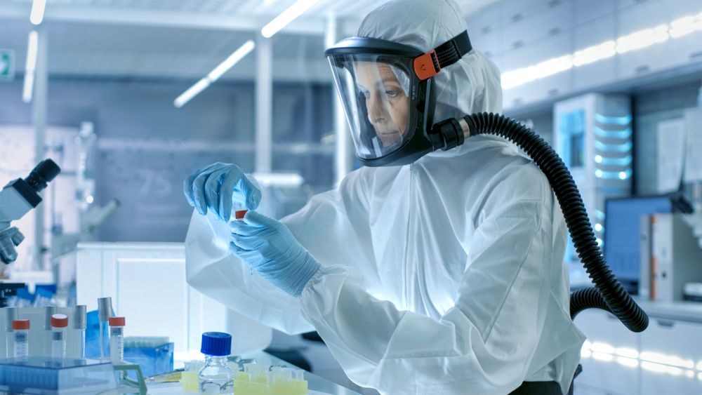 Medical Virology Research Scientist Works in a Hazmat Suit with Mask