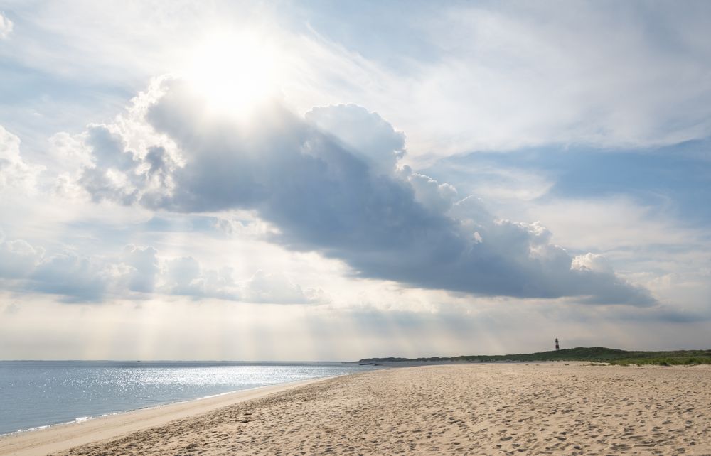 Sun peaking through clouds on the beach