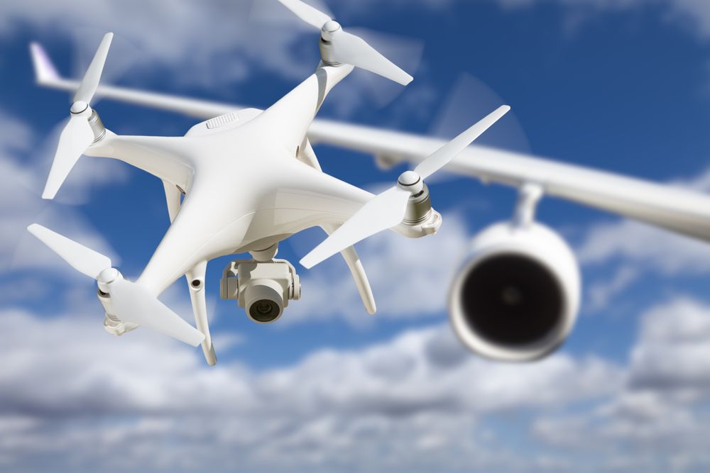 Unmanned Aircraft System (UAV) Quadcopter Drone In The Air Too Close To Passenger Airplane.