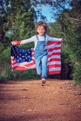 Boy with USA flag running on rural rural walkway