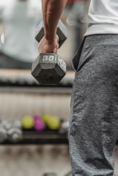 Cropped image of man holding gray dumbbell 5RJEJ5