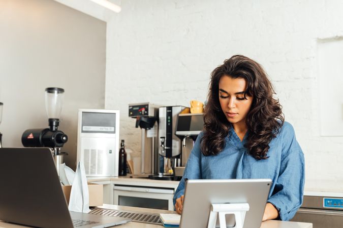 Woman taking notes at til of modern coffee shop